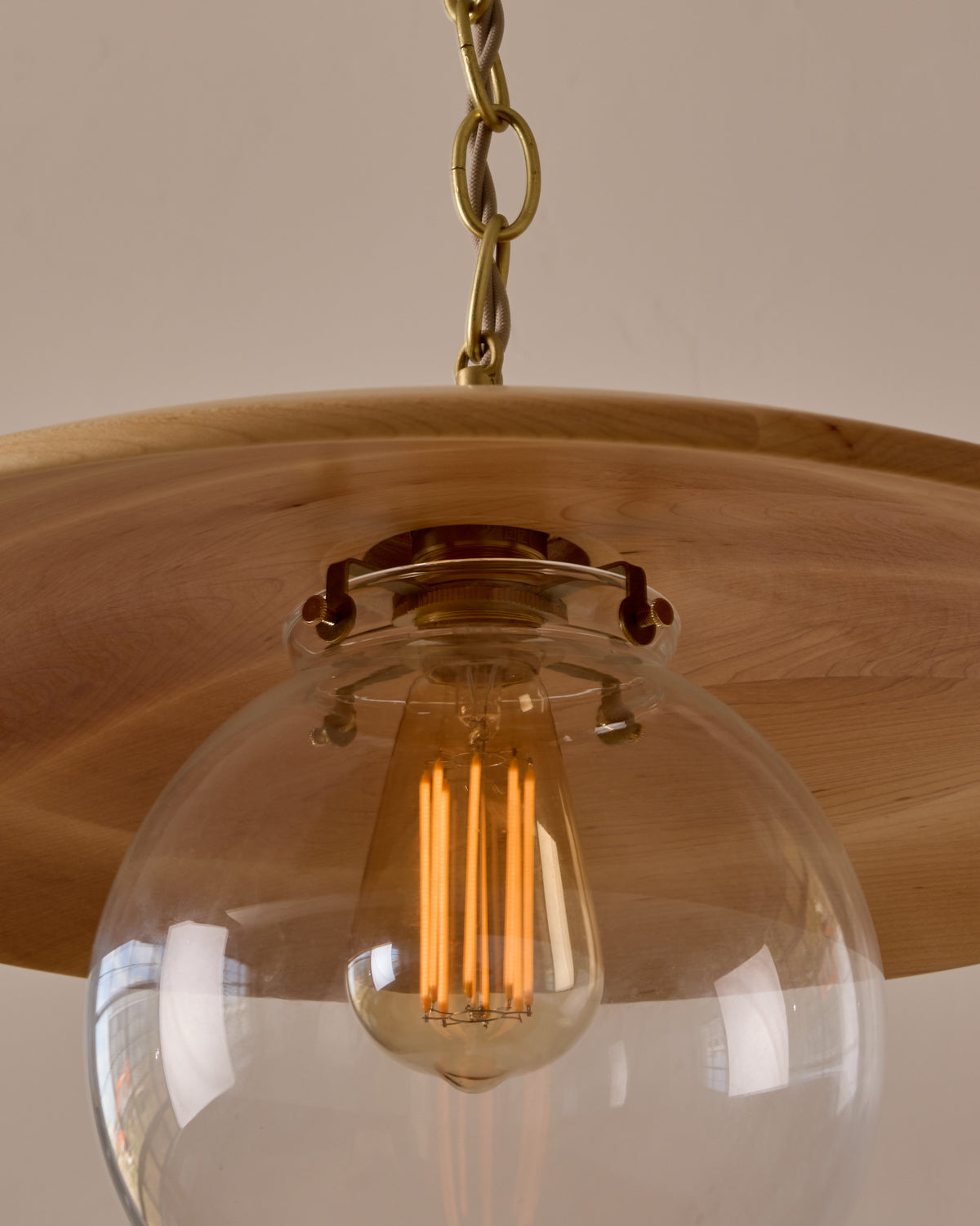 Large pendant light with oversized clear glass globe and decorative wooden clear maple shade with brass chain #shade-finish_natural maple #globe_clear glass #cord-color_beige