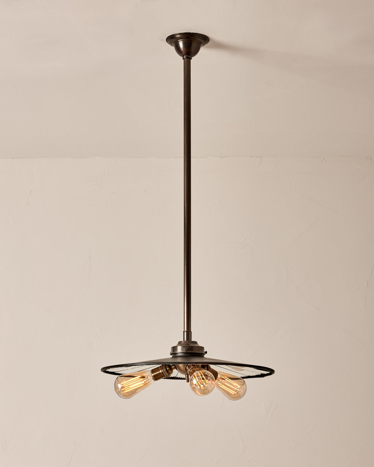 A vintage style pendant light with mirrored glass and a bronze shade hanging from the ceiling. #size_18" diameter