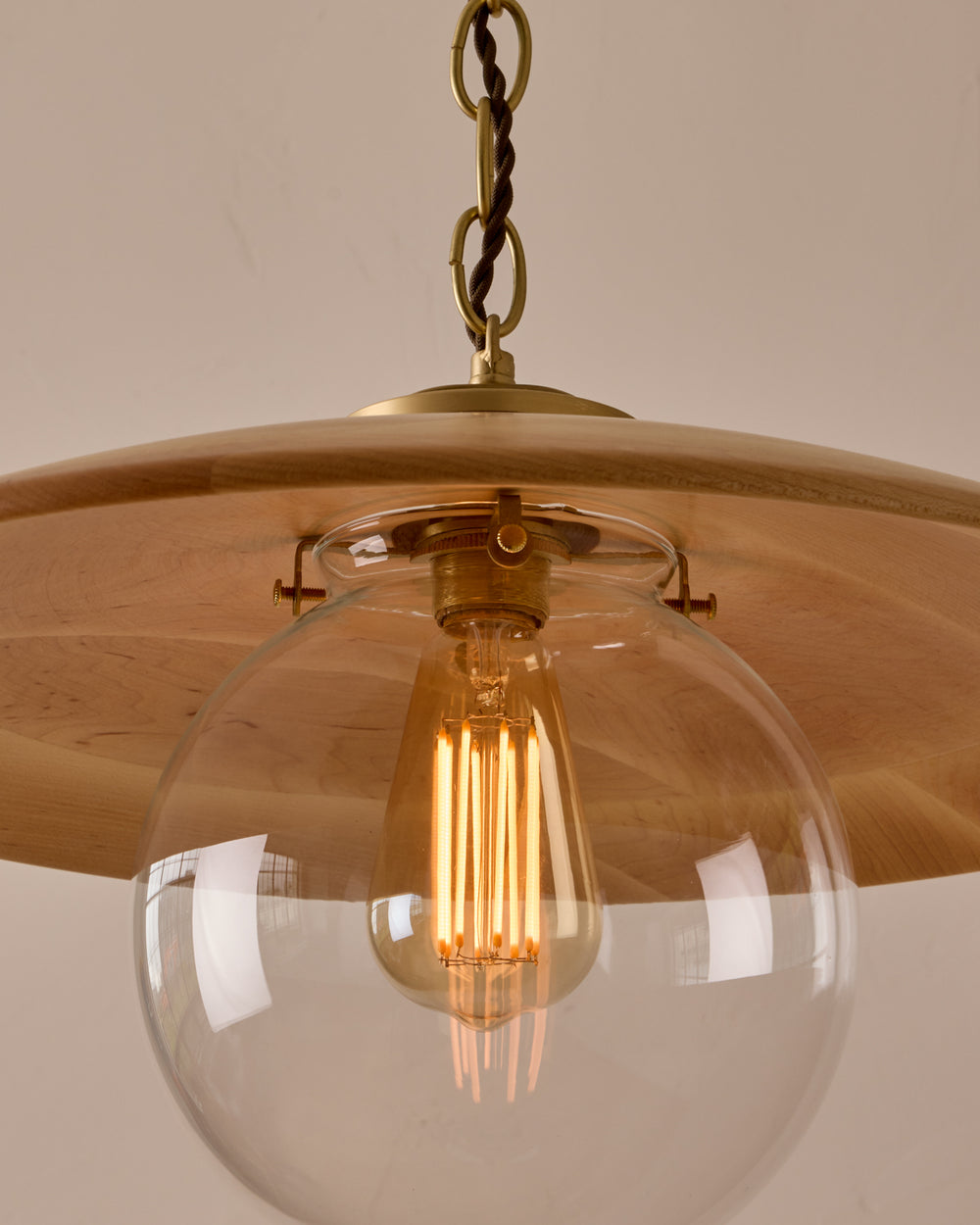 Large pendant light with oversized clear glass globe and decorative wooden clear maple shade with brass chain  #shade-finish_natural maple #globe_clear glass #cord-color_brown