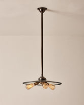 A vintage style pendant light with mirrored glass and a bronze shade hanging from the ceiling. #size_18" diameter