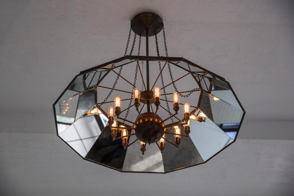 Victorian style metal chandelier with mirrored interior and edison bulbs