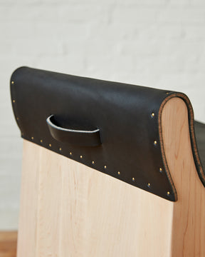 Leather pull handle of Sculpted stool with black leather and maple wooden base with metal foot rest and short backrest. Counter and bar height. Handmade in Philadelphia by Lostine. Simple Interior Design. Warm American Modern Design