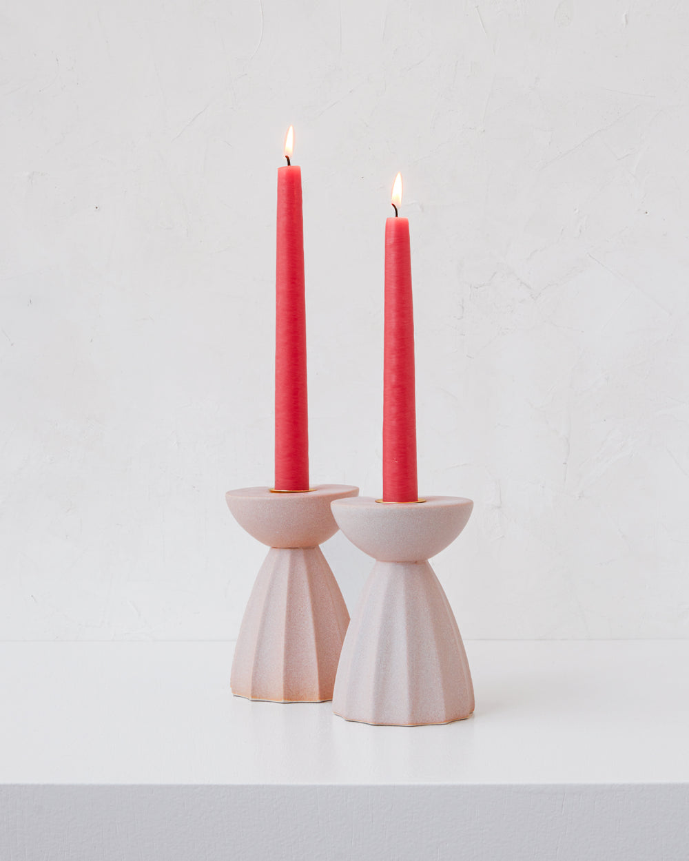 Blush Sabine ceramic candle holder with fluted ridged base in matte pink glaze with hot pink taper candles